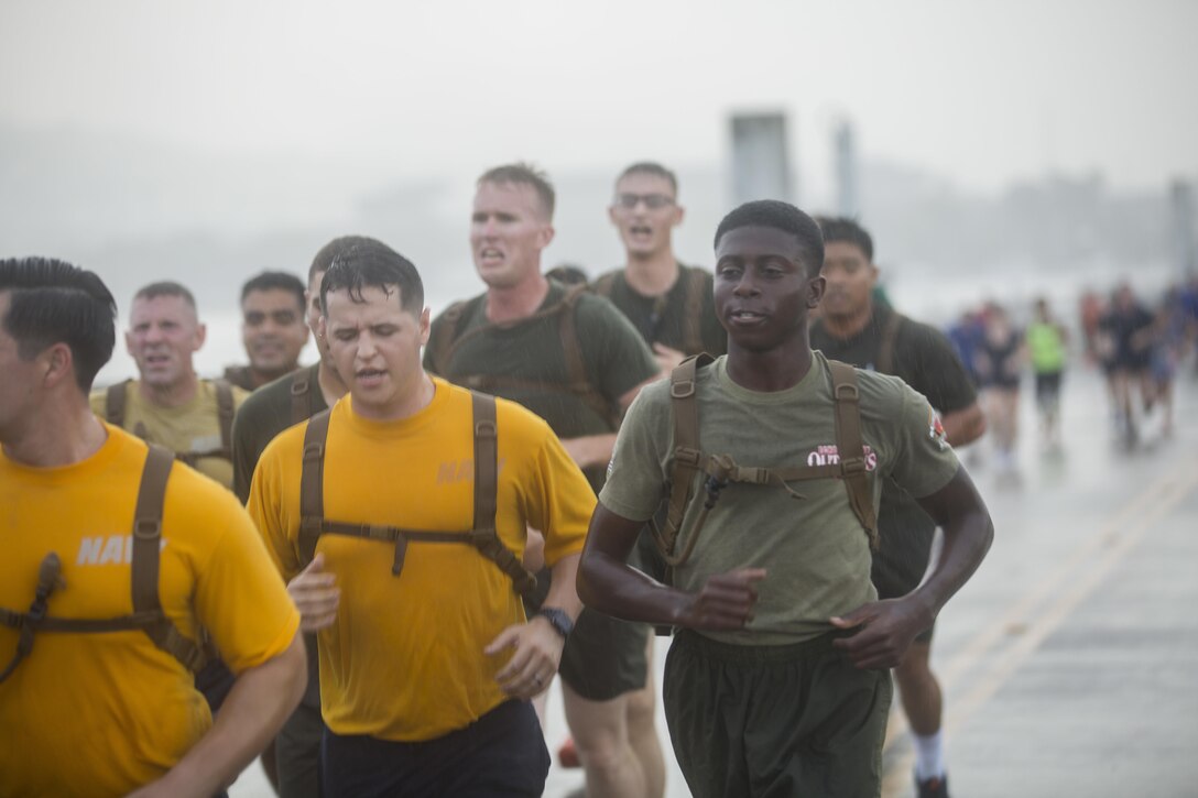 A U.S. Marine with 2nd Battalion, 3rd Marine Regiment, calls cadence during the Fisher House Hero and Remembrance Run, Walk or Roll 8k on Ford Island aboard Joint Base Pearl Harbor-Hickam, Sept. 9, 2017. The road was adorned with over 7,500 military boots decorated with American flags, name tags with a photo of the service member, and information on the combat tour they were serving or where they were stationed. The free event was open to the public and military to honor those we have lost in the service since Sept. 11, 2001. (U.S. Marine Corps photo by Sgt. Zachary Orr)