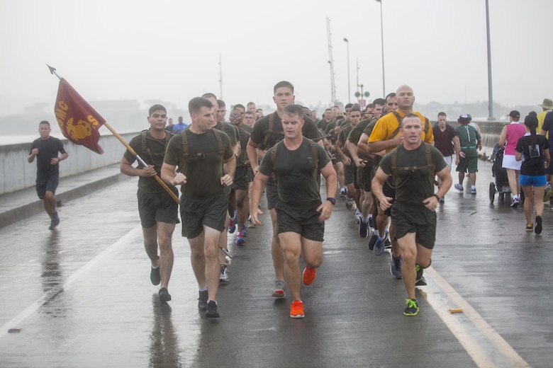 U.S. Marine Corps 1st Sgt. Roland McGinnis (right), Headquarters and Services company first sergeant with 2nd Battalion, 3rd Marine Regiment, leads his company in a formation run during the Fisher House Hero and Remembrance Run, Walk or Roll 8k on Ford Island aboard Joint Base Pearl Harbor-Hickam, Sept. 9, 2017. The road was adorned with over 7,500 military boots decorated with American flags, name tags with a photo of the service member, and information on the combat tour they were serving or where they were stationed. The free event was open to the public and military to honor those we have lost in the service since Sept. 11, 2001. (U.S. Marine Corps photo by Sgt. Zachary Orr)