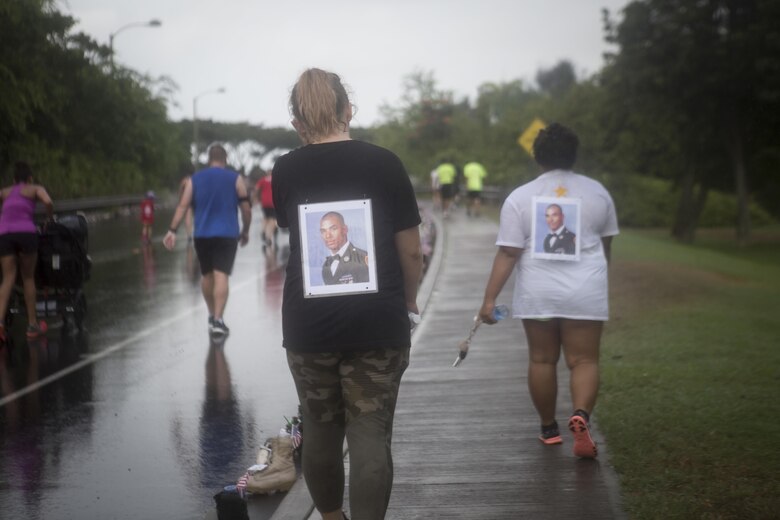 Run participants wear a photo of a fallen service member on their shirts during the Fisher House Hero and Remembrance Run, Walk or Roll 8k on Ford Island aboard Joint Base Pearl Harbor-Hickam, Sept. 9, 2017. The road was adorned with over 7,500 military boots decorated with American flags, name tags with a photo of the service member, and information on the combat tour they were serving or where they were stationed. The free event was open to the public and military to honor those we have lost in the service since Sept. 11, 2001. (U.S. Marine Corps photo by Sgt. Zachary Orr)