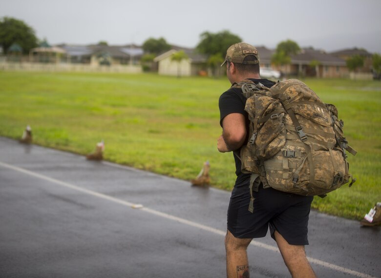 A run participant carries a pack during the Fisher House Hero and Remembrance Run, Walk or Roll 8k on Ford Island aboard Joint Base Pearl Harbor-Hickam, Sept. 9, 2017. The road was adorned with over 7,500 military boots decorated with American flags, name tags with a photo of the service member, and information on the combat tour they were serving or where they were stationed. The free event was open to the public and military to honor those we have lost in the service since Sept. 11, 2001. (U.S. Marine Corps photo by Sgt. Zachary Orr)