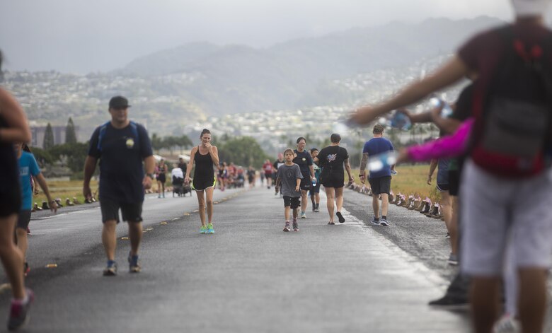 Run participants participate in the Fisher House Hero and Remembrance Run, Walk or Roll 8k on Ford Island aboard Joint Base Pearl Harbor-Hickam, Sept. 9, 2017. The road was adorned with over 7,500 military boots decorated with American flags, name tags with a photo of the service member, and information on the combat tour they were serving or where they were stationed. The free event was open to the public and military to honor those we have lost in the service since Sept. 11, 2001. (U.S. Marine Corps photo by Sgt. Zachary Orr)