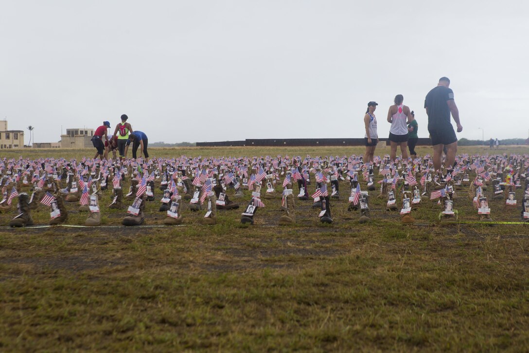 A display of boots with information of fallen Service members are set in a formation during the Fisher House Hero and Remembrance Run, Walk or Roll 8k, Ford Island, Joint Base Pearl Harbor-Hickam, Sept. 9, 2017. The road was adorned with over 7,500 military boots decorated with American flags, name tags with a photo of the Service member, and information on the combat tour they were serving or where they were stationed. The free event was open to the public and military to honor those we have lost in the Service since Sept. 11, 2001. (U.S. Marine Corps photo by Sgt. Zachary Orr)