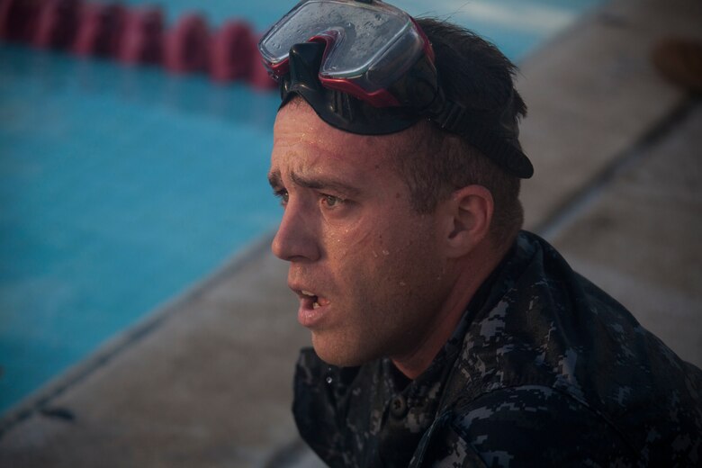 Seaman Anthony Ruiz, a craft master with Arizona Detachment, Joint Base Pearl Harbor-Hickam, rests after completing a water exercise at the base pool during the reconnaissance screener aboard Marine Corps Base Hawaii (MCBH) on Sept. 8, 2017. Screeners with 3rd Reconnaissance Battalion evaluated service members interested in attending the Basic Reconnaissance Course with a physical fitness test, aquatic exercises at the base pool, followed by the maneuver under fire portion of the combat fitness test twice, ending with a 6-mile-long pack run. (U.S. Marine Corps photo by Cpl. Jesus Sepulveda Torres)