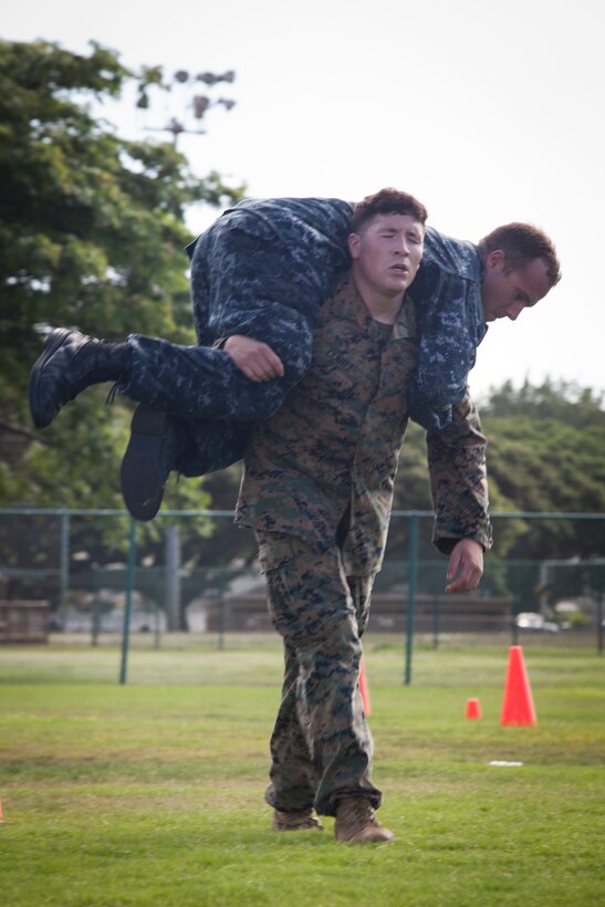 Lance Cpl. Robert Cortez, a rifleman with 2nd Battalion, 3rd Marine Regiment, carries Seaman Anthony Ruiz, a craft master with Arizona Detachment, Joint Base Pearl Harbor-Hickam, during the combat fitness test (CFT) portion part of the reconnaissance screener aboard Marine Corps Base Hawaii (MCBH) on Sept. 8, 2017. Screeners with 3rd Reconnaissance Battalion evaluated service members interested in attending the Basic Reconnaissance Course with a physical fitness test, aquatic exercises at the base pool, followed by the maneuver under fire portion of the CFT twice, ending with a 6-mile-long pack run. (U.S. Marine Corps photo by Cpl. Jesus Sepulveda Torres)