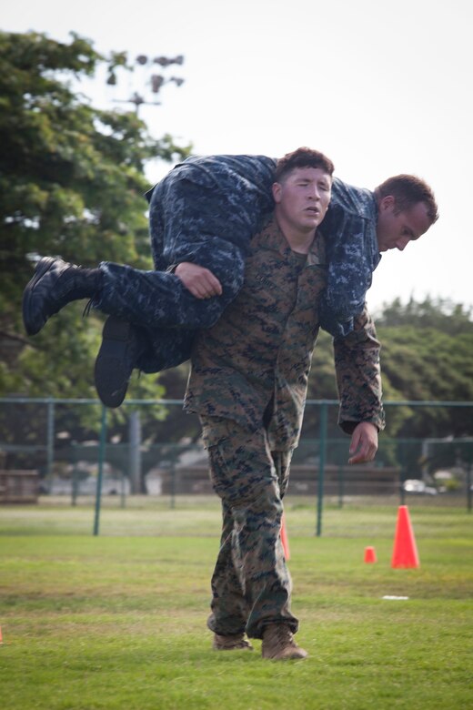 Lance Cpl. Robert Cortez, a rifleman with 2nd Battalion, 3rd Marine Regiment, carries Seaman Anthony Ruiz, a craft master with Arizona Detachment, Joint Base Pearl Harbor-Hickam, during the combat fitness test (CFT) portion part of the reconnaissance screener aboard Marine Corps Base Hawaii (MCBH) on Sept. 8, 2017. Screeners with 3rd Reconnaissance Battalion evaluated service members interested in attending the Basic Reconnaissance Course with a physical fitness test, aquatic exercises at the base pool, followed by the maneuver under fire portion of the CFT twice, ending with a 6-mile-long pack run. (U.S. Marine Corps photo by Cpl. Jesus Sepulveda Torres)