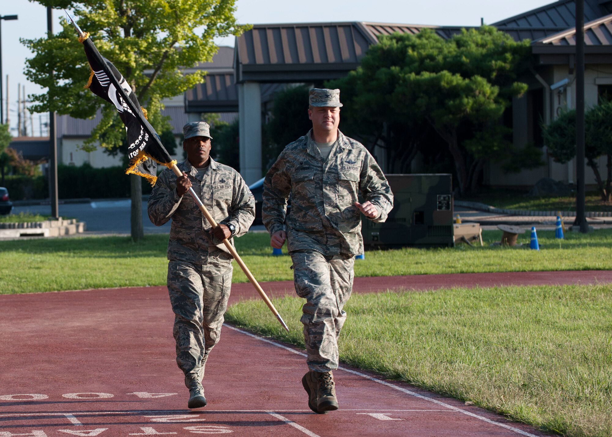 U.S. Air Force Col. David G. Shoemaker, 8th Fighter Wing commander, and Chief Master Sgt. Reiko L. Meeks, 8th FW command chief, run with the Prisoner of War and Missing in Action flag during the opening ceremony of POW/MIA Recognition Day at Kunsan Air Base, Republic of Korea, Sept. 14, 2017. Shoemaker and Meeks ran the first leg of the 24-hour run in remembrance of the POW/MIA service members. (U.S. Air Force photo by Staff Sgt. Victoria H. Taylor)