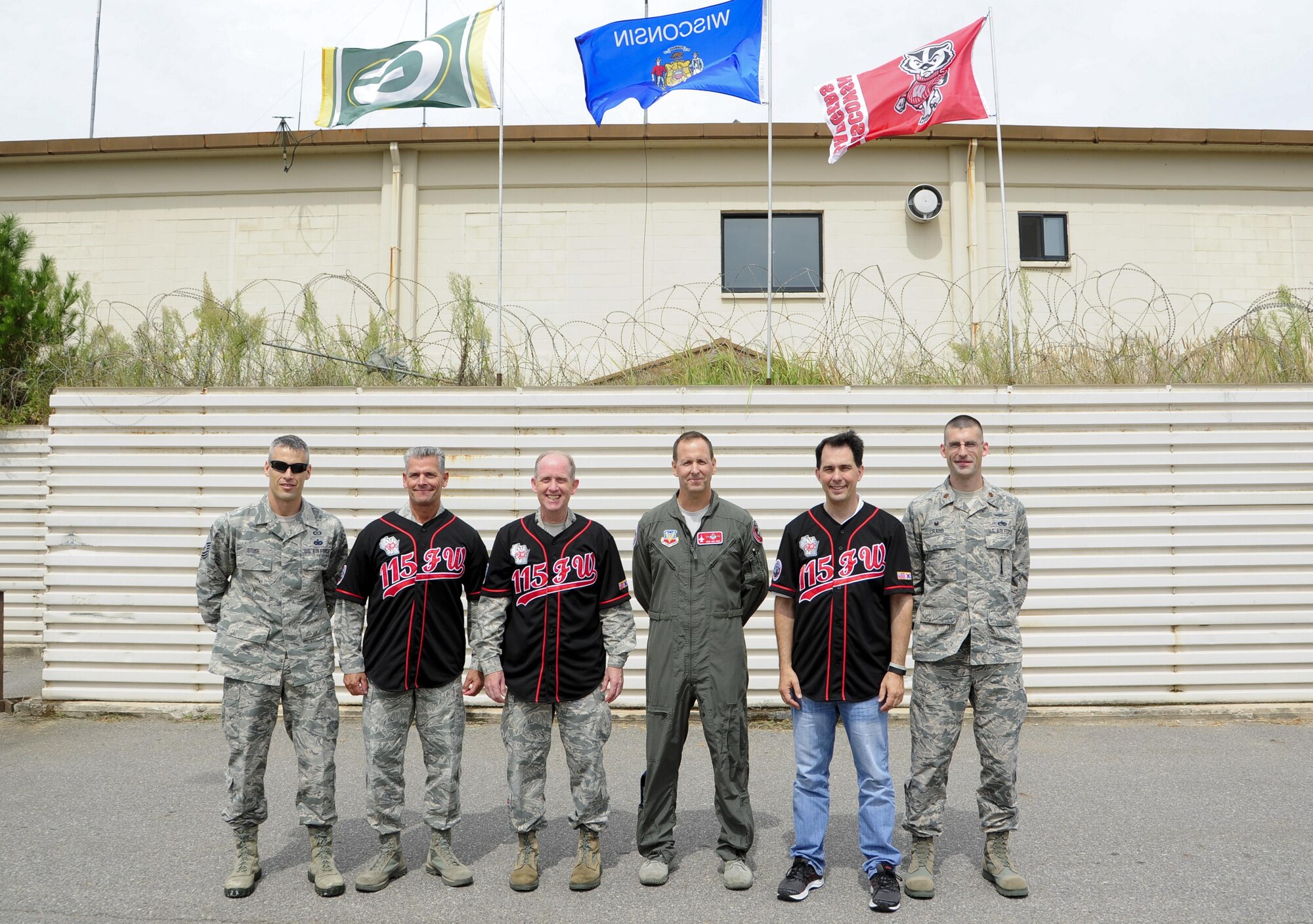 U.S. Air Force Chief Master Sgt. Thomas Safer, 115th Fighter Wing, Wisconsin Air National Guard command chief (left), Maj. Gen. Donald Dunbar, Wisconsin‘s adjutant general (middle), and The Honorable Scott Walker, Governor of Wisconsin (right), wear traditional Wolf Pack jerseys presented by 115th FW leadership at Kunsan Air Base, Republic of Korea, Sept. 16, 2017. Walker and Wisconsin Air National Guard leadership visited Airmen from the 115th FW deployed to Kunsan for a 4-month rotation as part of a Theater Security Package, which helps to maintain regional security and stability. (U.S. Air Force photo by Senior Airman Colby L. Hardin)