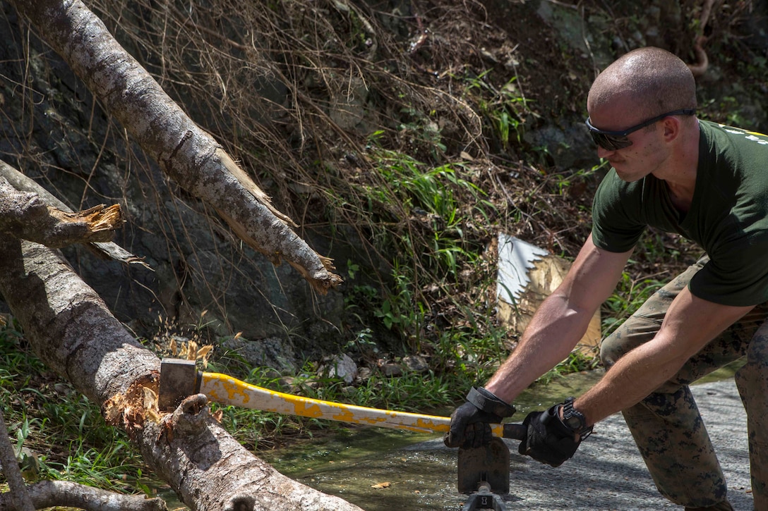 U.S. Marine Corps Sgt. Austin C. Morgan, an assaultman with Battalion Landing Team 2nd Battalion, 6th Marine Regiment, 26th Marine Expeditionary Unit (MEU), to clear debris at a local fire station that was affected by Hurricane Irma in St. John, U.S. Virgin Islands, Sept. 17, 2017.