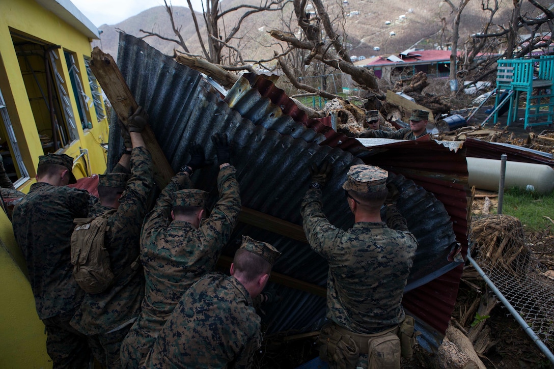 U.S. Marine Corps Sgt. Austin C. Morgan, an assaultman with Battalion Landing Team 2nd Battalion, 6th Marine Regiment, 26th Marine Expeditionary Unit (MEU), to clear debris at a local fire station that was affected by Hurricane Irma in St. John, U.S. Virgin Islands, Sept. 17, 2017.