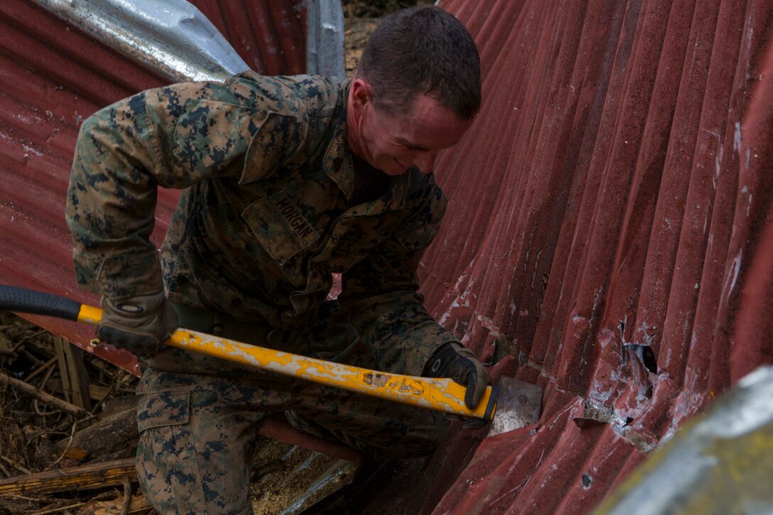 U.S. Marine Corps Sgt. Austin C. Morgan, an assaultman with Battalion Landing Team 2nd Battalion, 6th Marine Regiment, 26th Marine Expeditionary Unit (MEU), to clear debris at a local fire station that was affected by Hurricane Irma in St. John, U.S. Virgin Islands, Sept. 17, 2017.