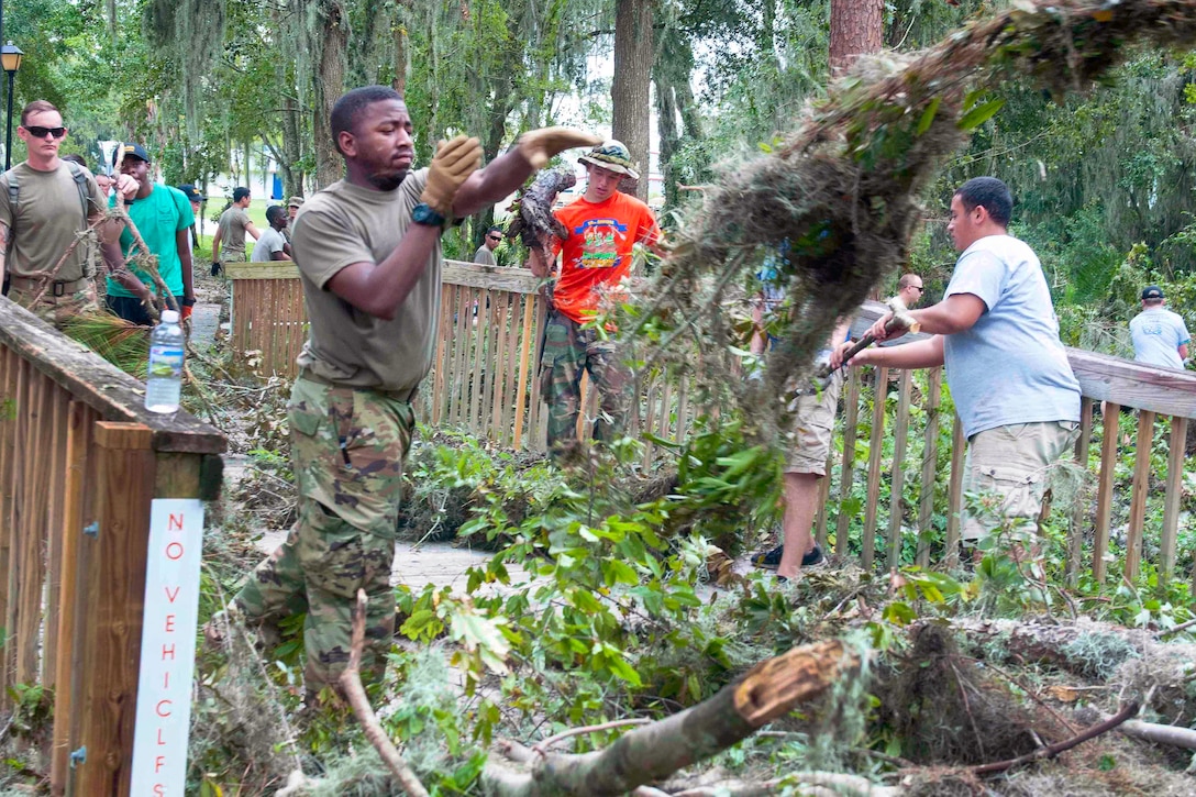 Soldiers clean up tree branches in the wake of Hurricane Irma.