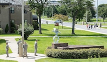 Four members of Team Dover stand vigilant at the base flag pole as a group of runners jog by them during National Prisoner of War and Missing in Action Recognition Day Sept. 15, 2017, on Dover Air Force Base, Del. Running and standing in shifts, 343 runners participated in a 24-hour run and 236 stood at the flag pole as part of the recognition day events. (U.S. Air Force photo by Roland Balik)