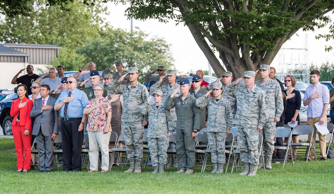 Team Dover members and guests render a salute or place their hand over their heart while the base honor guard lowers the U.S. flag during the National Prisoner of War and Missing in Action Recognition Day ceremony Sept. 15, 2017, on Dover Air Force Base, Del. One hundred seventy-eight fallen service members from previous wars and conflicts were repatriated this past year. (U.S. Air Force photo by Roland Balik)