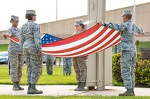 Members of the Dover Air Force Base Honor Guard prepare to fold the U.S. flag during the National Prisoner of War and Missing in Action Recognition Day ceremony Sept. 15, 2017, on Dover Air Force Base, Del. Positioned left to right, Senior Airman Kiara Hammett, 436th Aerospace Medical Squadron; Airman 1st Class Clair Boyles, 436th Logistics Readiness Squadron; Airman 1st Class Jessica Shaffer, 436th Operations Support Squadron; and Senior Airman Edcyril Mallonga, 436th Civil Engineer Squadron; presented the folded flag to Col. Corey Simmons, 436th Airlift Wing vice commander. (U.S. Air Force photo by Roland Balik)