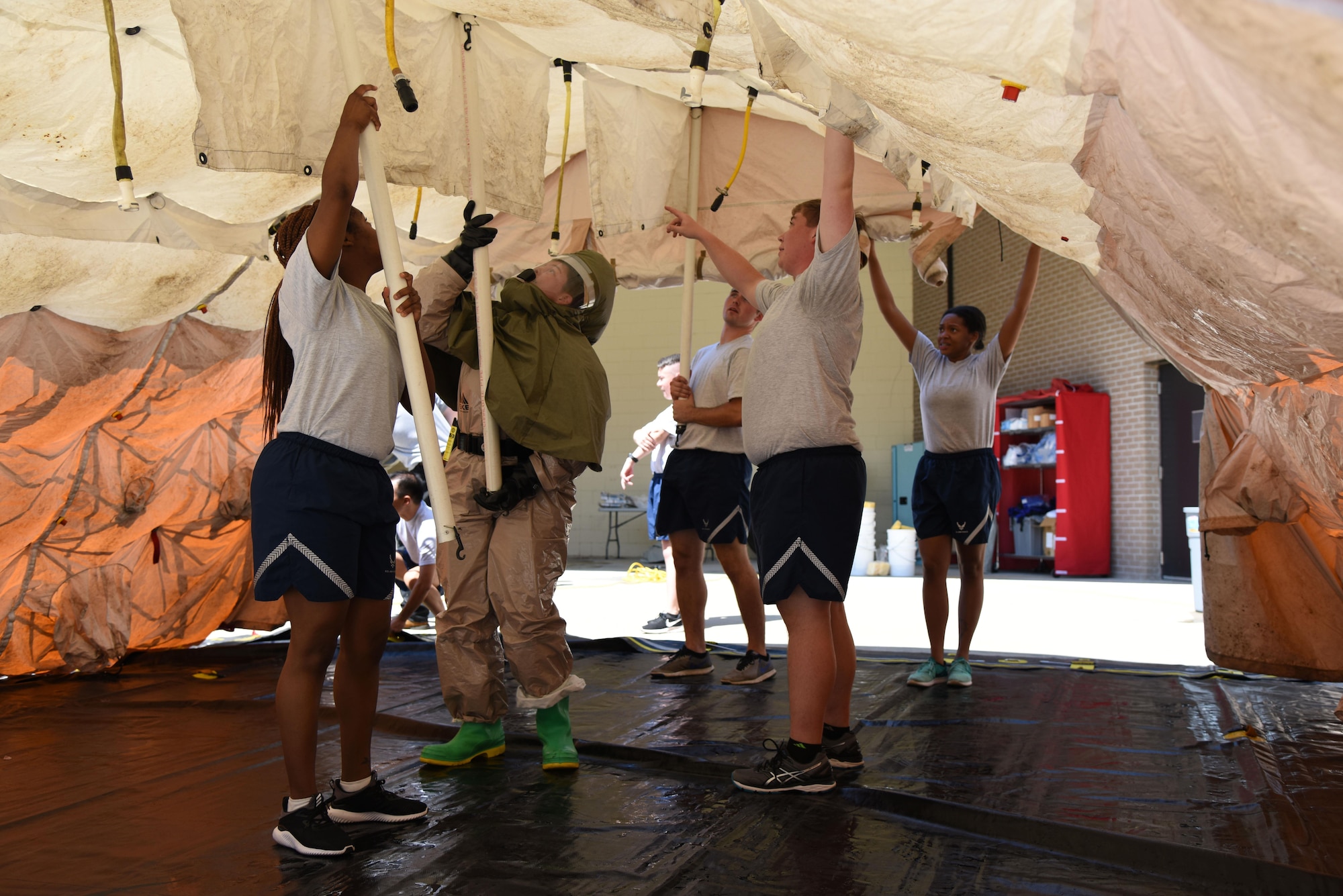 Members of the 81st Medical Group assemble a decontamination tent during the 81st MDG integrated in-place patient decontamination training course behind the Keesler Medical Center Sept. 14, 2017, on Keesler Air Force Base, Mississippi. The two-day course trained 21 personnel, which came from four different disaster medical teams: IPPD, triage, manpower and security. Throughout the training, they learned to utilize Keesler’s fixed decontamination facility and how to set up and tear down the decontamination tent. (U.S. Air Force photo by Kemberly Groue)