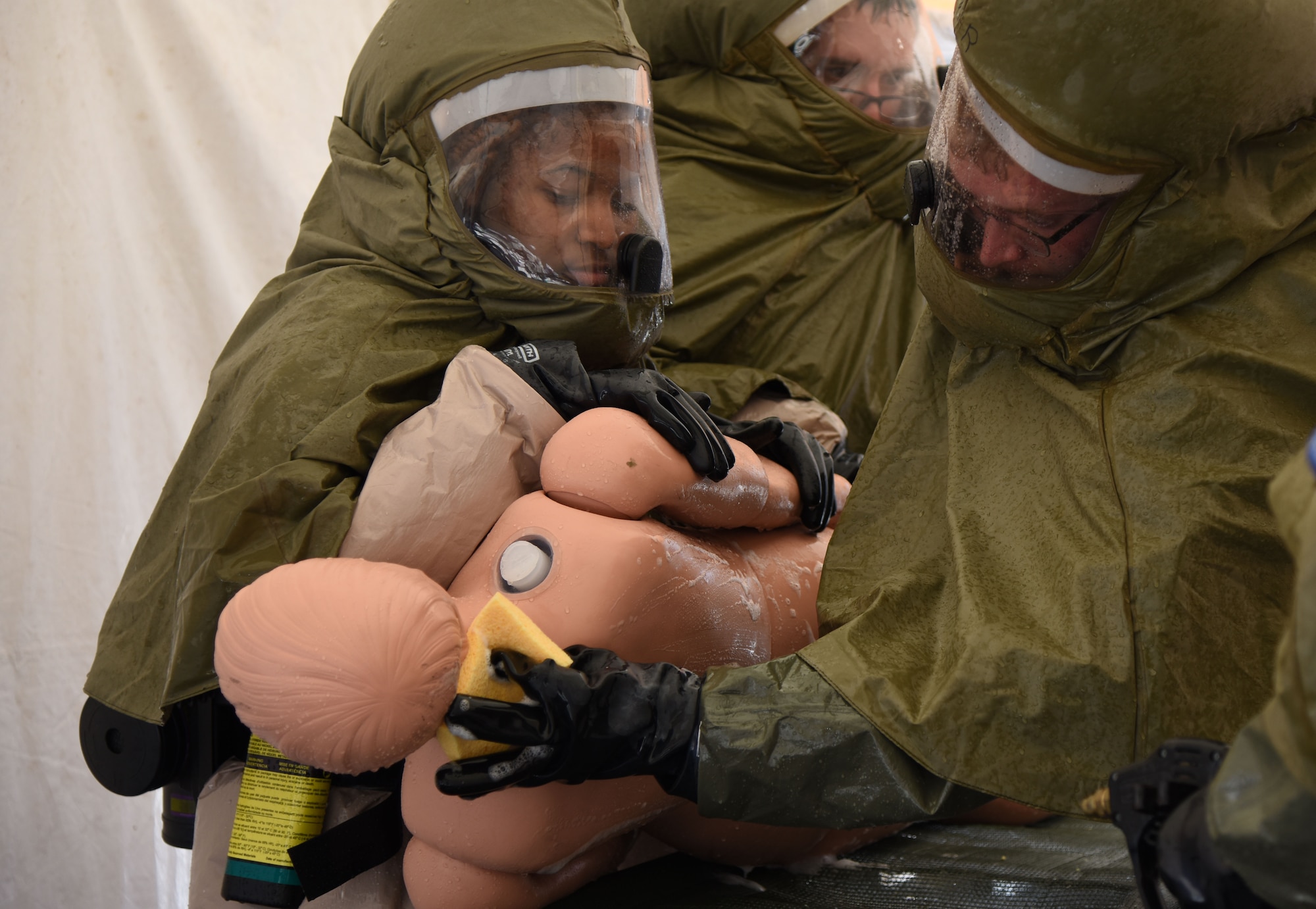 Airman 1st Class D’Asia Nelson-Clark, 81st Surgical Operations Squadron surgical technician, and Airman 1st Class Andrew Long, 81st MSGS ophthalmology technician, wash a “patient” as they are moved through a decontamination tent during the 81st Medical Group integrated in-place patient decontamination training course behind the Keesler Medical Center Sept. 14, 2017, on Keesler Air Force Base, Mississippi. The two-day course trained 21 personnel, which came from four different disaster medical teams: IPPD, triage, manpower and security. Throughout the training, they learned to utilize Keesler’s fixed decontamination facility and how to set up and tear down the decontamination tent. (U.S. Air Force photo by Kemberly Groue)