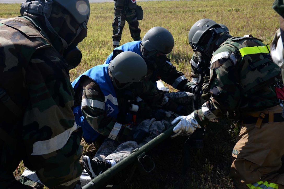 A group of people put an airman on a stretcher