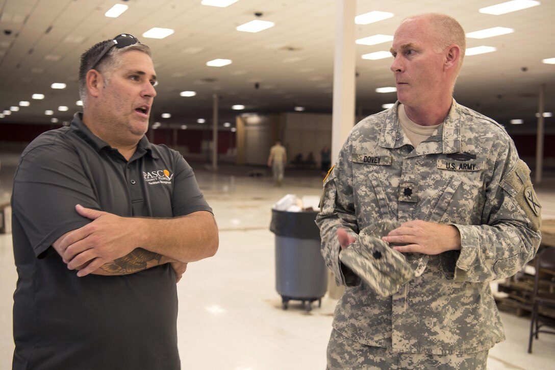 Army Lt. Col. Michael Dovey talks to a county representative.