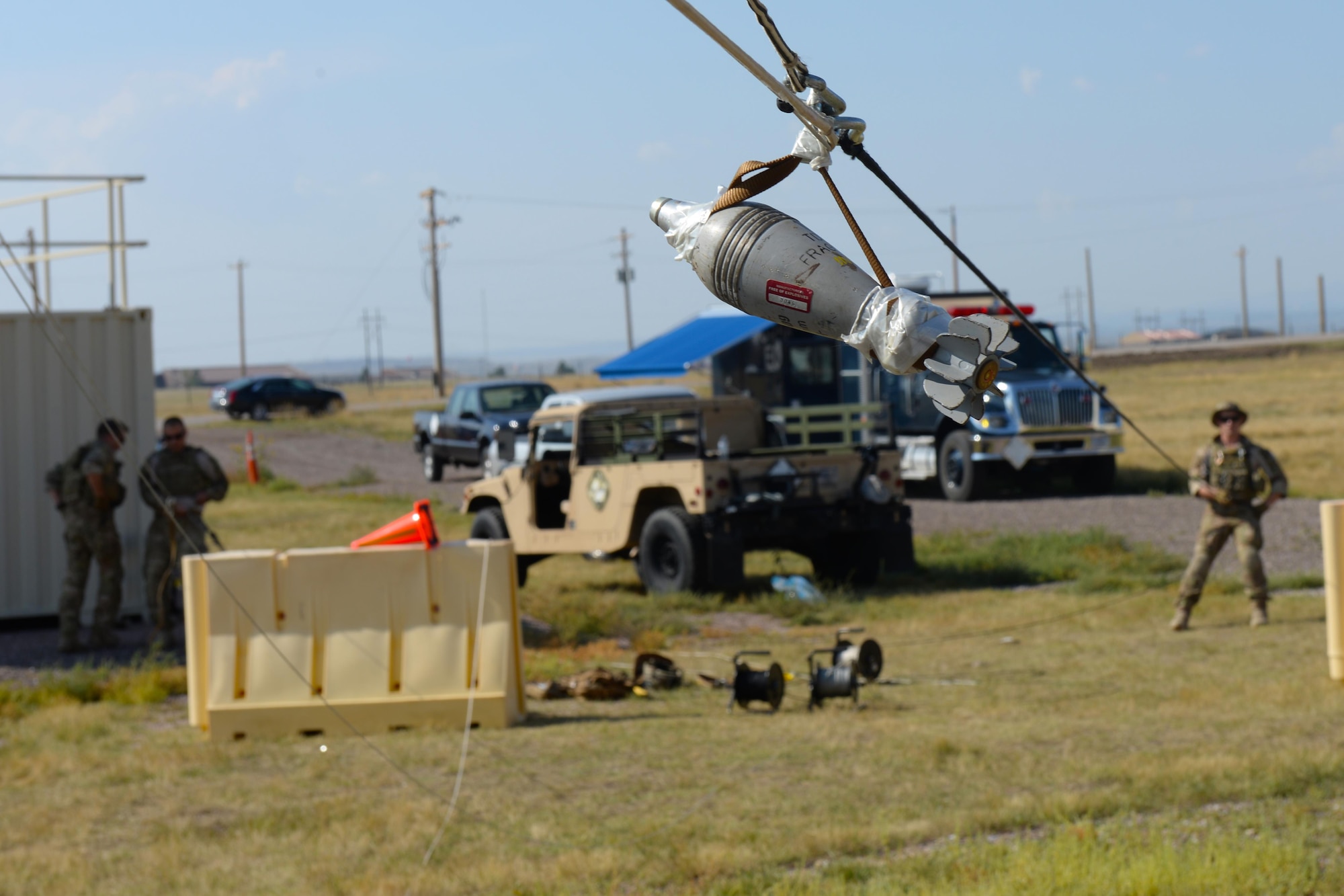 Three explosive ordnance disposal technicians assigned to the 28th Civil Engineer Squadron hoist an unexploded ordnance during an EOD Team of the Year competition at Ellsworth Air Force Base, S.D., Sept. 12, 2017. During this scenario, technicians had to take into account the placement of different obstacles such as ledges, walls, and door frames to ensure that the fake explosive didn’t simulate detonating. (U.S. Air Force photo by Airman Nicolas Z. Erwin)