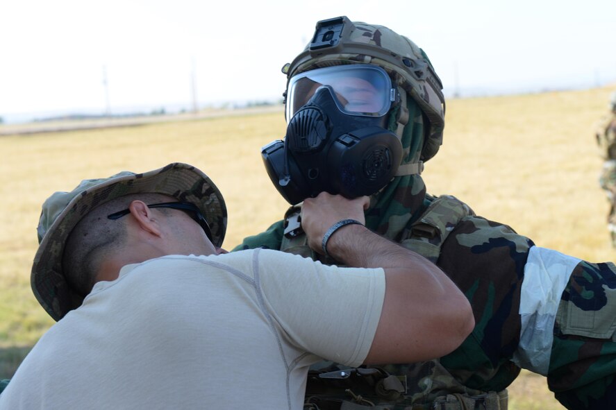 Senior Airman Parker Davis, an explosive ordnance disposal technician assigned to the 28th Civil Engineer Squadron, is inspected by Master Sgt. Carlos Sanchez, the EOD section chief assigned to the 28th CES, during an EOD Team of the Year competition at Ellsworth Air Force Base, S.D., Sept. 12, 2017. The chemical scenario during the event simulated the need for a leak seal and package in a decontamination line. (U.S. Air Force photo by Airman Nicolas Z. Erwin)