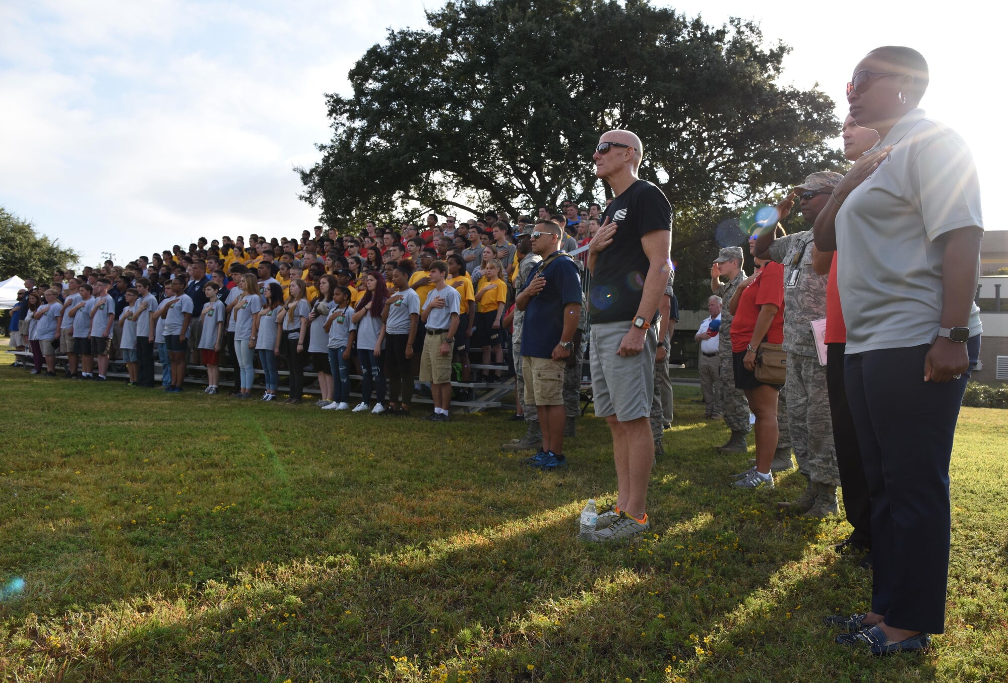 Keesler personnel and local high school Junior ROTC cadets place their hands over their hearts during the singing of the national anthem at the Science, Technology, Engineering and Mathematics Diversity Outreach Day Sept. 15, 2017, on Keesler Air Force Base, Mississippi. The event consisted of 10 Mississippi gulf coast high school Junior ROTC units viewing an 81st Security Forces Squadron military working dog demonstration and receiving information about Air Force opportunities and accession requirements with an emphasis on STEM. They also competed in several team building activities. (U.S. Air Force photo by Kemberly Groue)