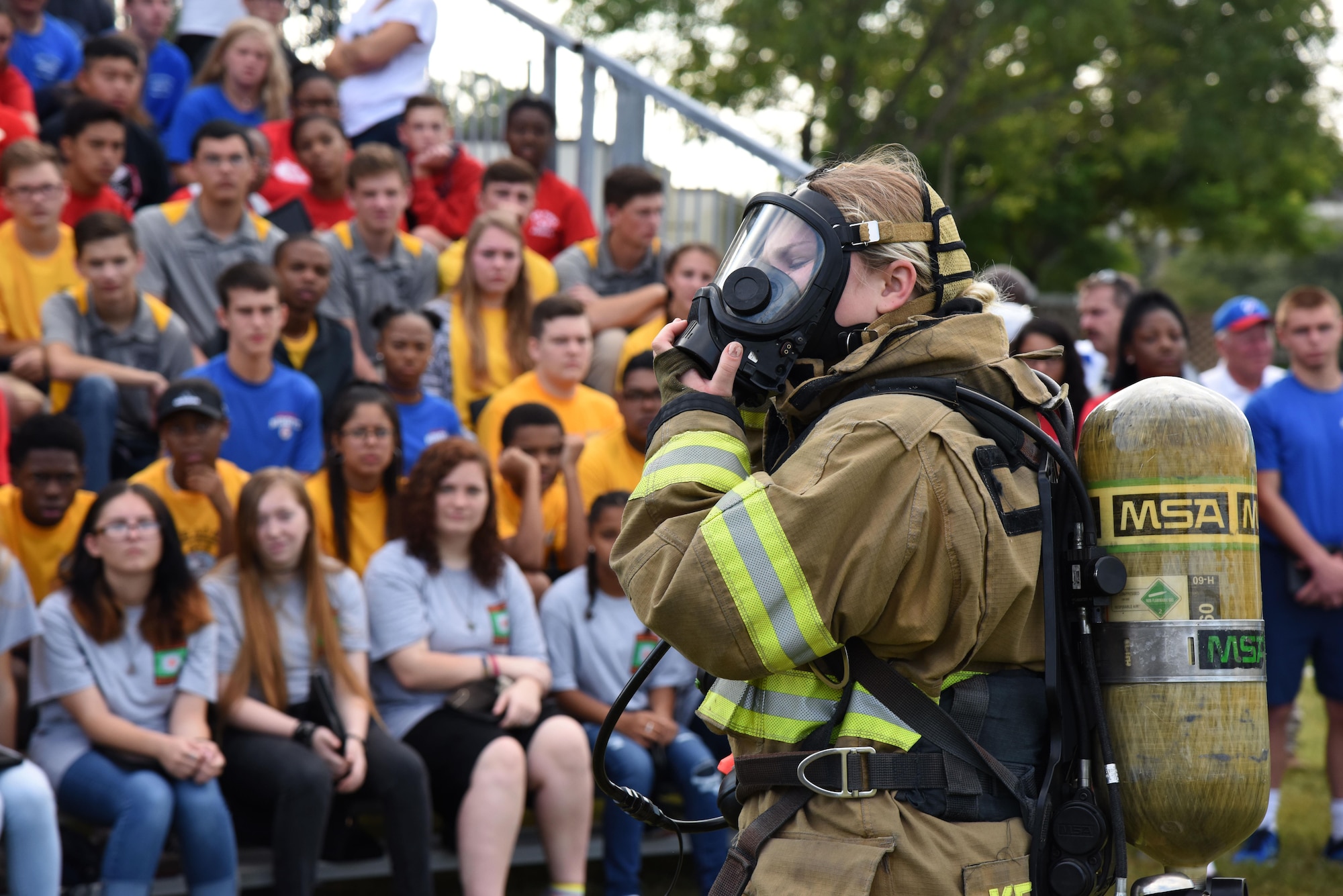 Airman 1st Class Hannah Reichert, 81st Infrastructure Division firefighter, demonstrates how to quickly put on firefighter gear at the Science, Technology, Engineering and Mathematics Diversity Outreach Day Sept. 15, 2017, on Keesler Air Force Base, Mississippi. The event consisted of 10 Mississippi gulf coast high school Junior ROTC units viewing an 81st Security Forces Squadron military working dog demonstration and receiving information about Air Force opportunities and accession requirements with an emphasis on STEM. They also competed in several team building activities. (U.S. Air Force photo by Kemberly Groue)