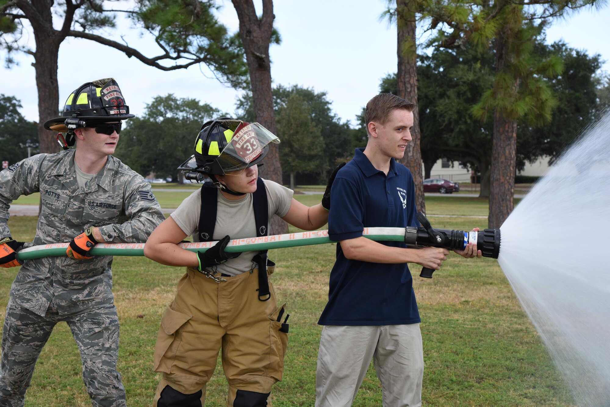 Staff Sgt. Codee Potts, and Airman 1st Class Hannah Reichert, 81st Infrastructure Division firefighters, assist Riley McElfish, Bay High School Junior ROTC cadet, with operating a fire hose at the Science, Technology, Engineering and Mathematics Diversity Outreach Day Sept. 15, 2017, on Keesler Air Force Base, Mississippi. The event consisted of 10 Mississippi gulf coast high school Junior ROTC units viewing an 81st Security Forces Squadron military working dog demonstration and receiving information about Air Force opportunities and accession requirements with an emphasis on STEM. They also competed in several team building activities. (U.S. Air Force photo by Kemberly Groue)