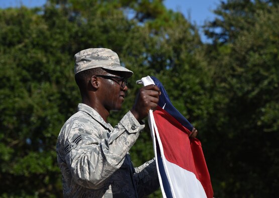 Senior Airman Kadeem Daniel, 81st Contracting Squadron contracting administrator, participates in a flag folding ceremony during the POW/MIA Retreat Ceremony Sept. 15, 2017, on Keesler Air Force Base, Mississippi. The event, hosted by the Air Force Sergeants Association Chapter 652, was held to raise awareness and pay tribute to all prisoners of war and military members still missing in action. (U.S. Air Force photo by Kemberly Groue)