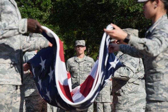 Tech. Sgt. Kevin Seney, 335th Training Squadron instructor, participates in a flag folding ceremony during the POW/MIA Retreat Ceremony Sept. 15, 2017, on Keesler Air Force Base, Mississippi. The event, hosted by the Air Force Sergeants Association Chapter 652, was held to raise awareness and pay tribute to all prisoners of war and military members still missing in action. (U.S. Air Force photo by Kemberly Groue)