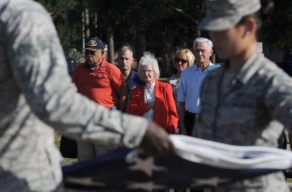 Retired U.S. Marine Corps Capt. Henry Harris, Anna Caire, spouse of Retired Master Sgt. James Caire, former Prisoner of War, and Lt. Col. Barry Bridger, former Prisoner of War, show their respect during the POW/MIA Retreat Ceremony Sept. 15, 2017, on Keesler Air Force Base, Mississippi. The event, hosted by the Air Force Sergeants Association Chapter 652, was held to raise awareness and pay tribute to all prisoners of war and military members still missing in action. (U.S. Air Force photo by Kemberly Groue)