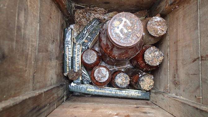 Jars containing potentially explosive chemicals are positioned in a wooden box with C-4 demolition explosives at the Big Seven mining complex Sept. 14, 2017, in Neihart, Mont.