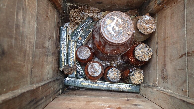 Jars containing potentially explosive chemicals are positioned in a wooden box with C-4 demolition explosives at the Big Seven mining complex Sept. 14, 2017, in Neihart, Mont.