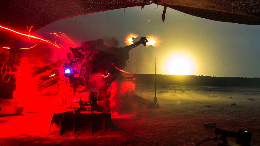 Marines fire a howitzer in the field.