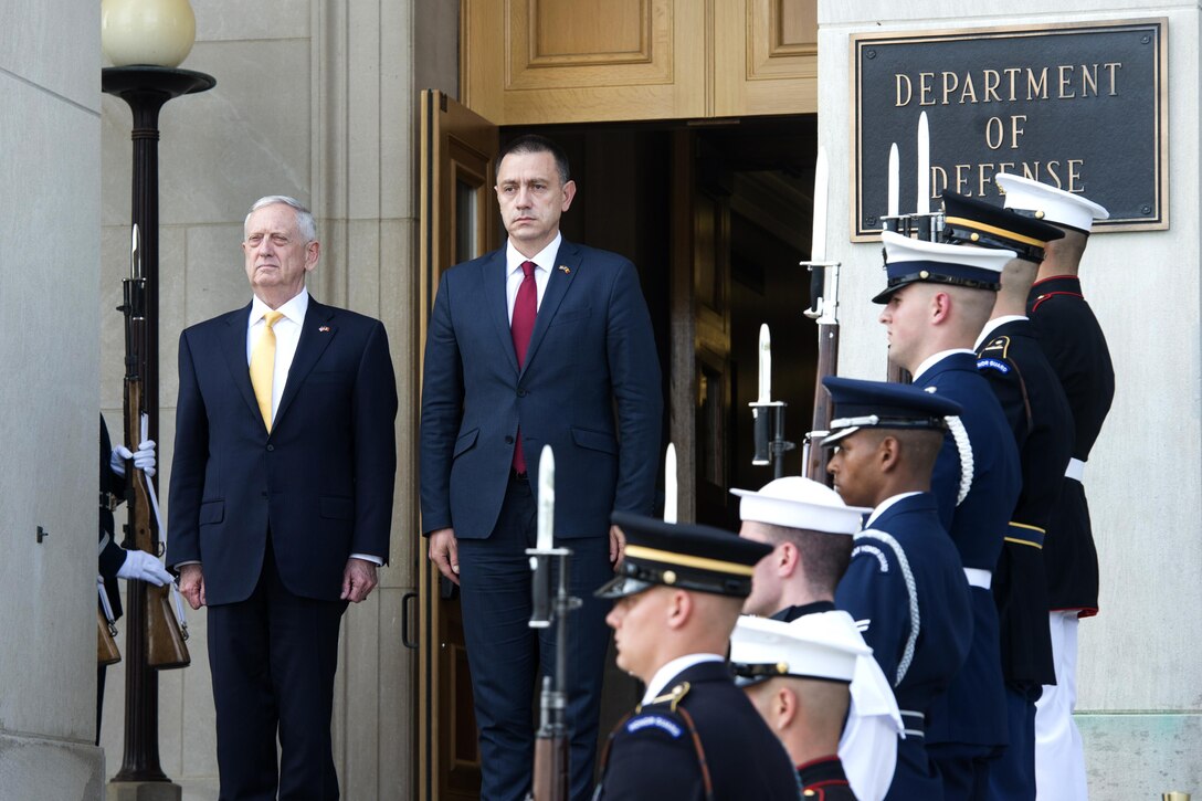Defense Secretary Jim Mattis stands with the Romanian defense minister on steps.