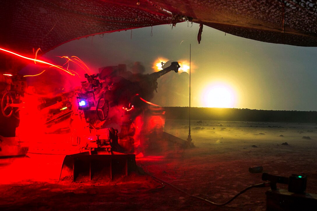 Marines fire a howitzer in the field.