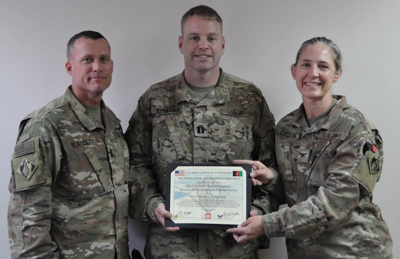 U.S. Army Corps of Engineers’ Transatlantic Afghanistan Marmal Resident Office OIC U.S. Army Capt. Daniel Strasser receives his combat patch from USACE TAA District Commander U.S. Army Col. Kimberly Colloton at Camp Marmal, Sept. 19.