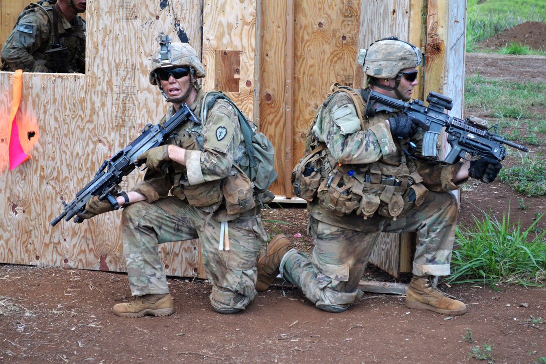 Soldiers provide security around a building after seizing it during a live-fire exercise.