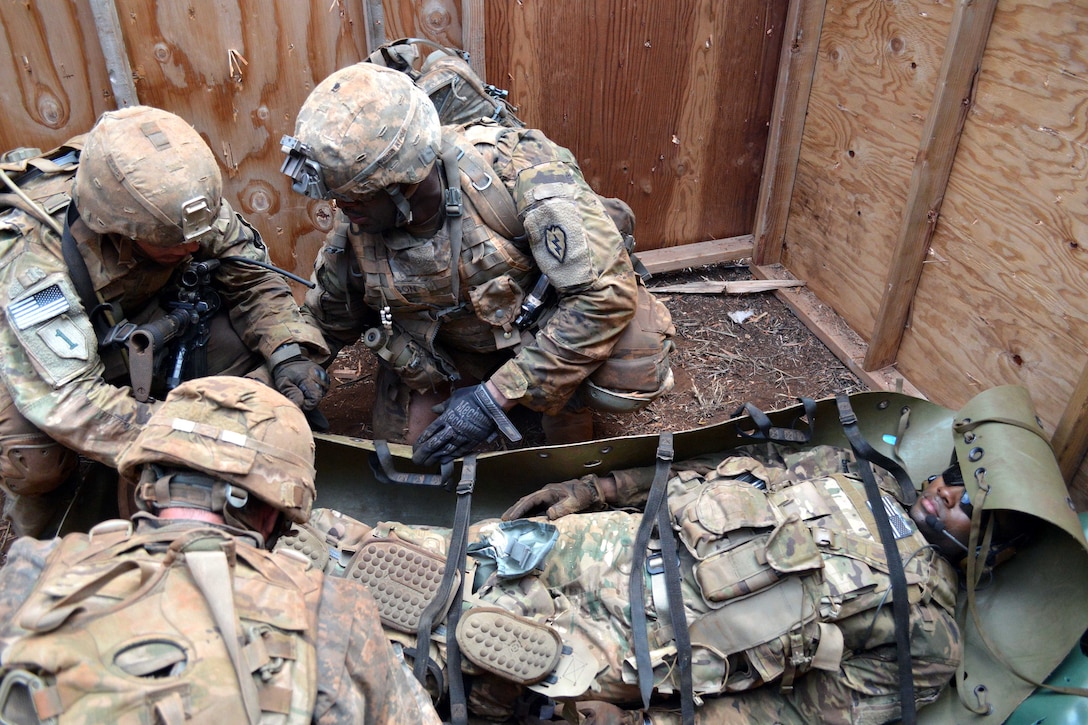 Soldiers treat a mock casualty during a live-fire exercise.