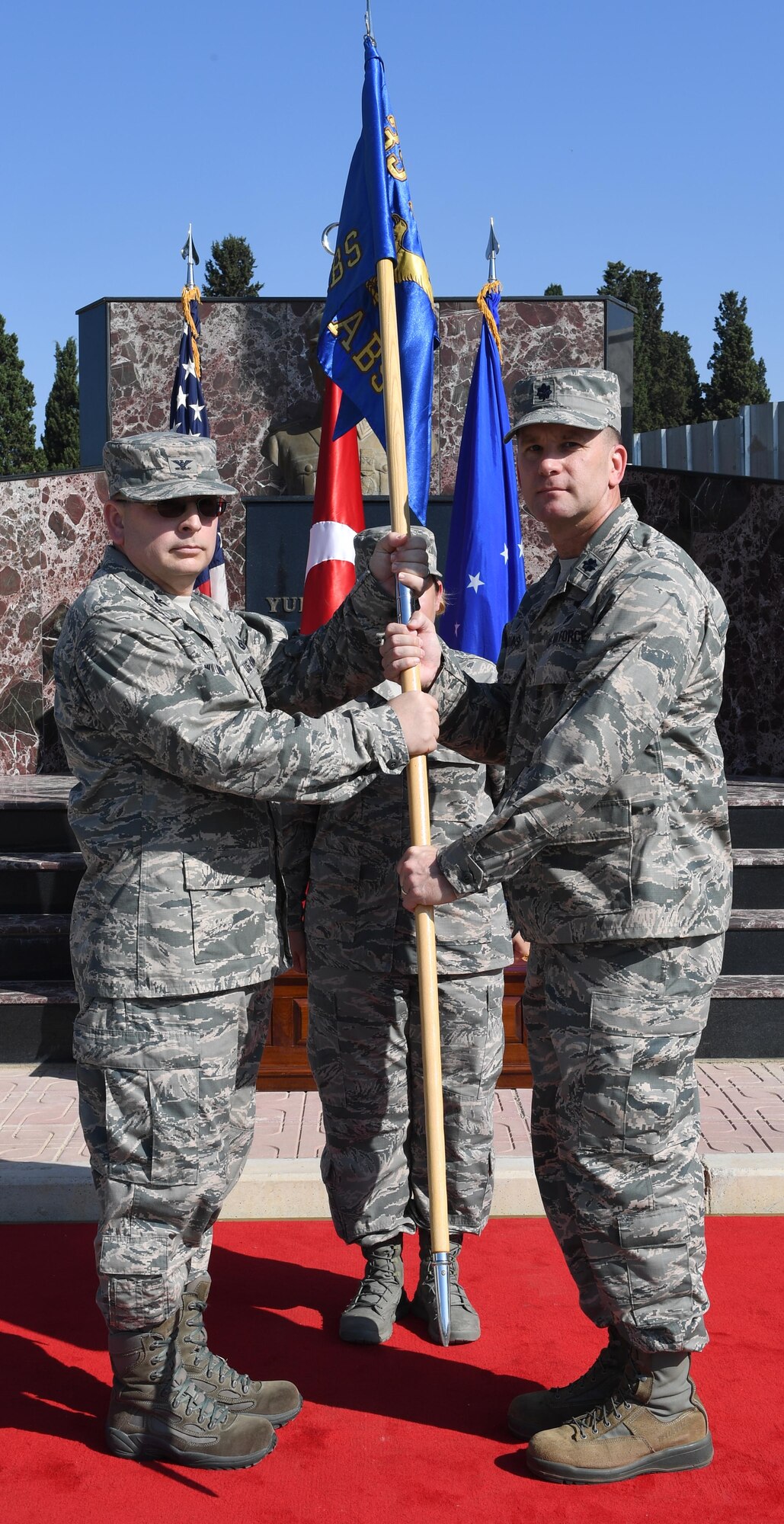 U.S. Air Force Col. David Williams, 39th Mission Support Group commander (left), passes the guidon to Lt. Col. Christopher Collins (right), 425th Air Base Squadron incoming commander, during an Assumption of Command at Izmir Air Station, Turkey, Sept. 18, 2017. Collins was previously assigned to the 451st Flying Training Squadron as a combat systems instructor. (U.S. Air Force photo by Senior Airman Jasmonet D. Jackson)