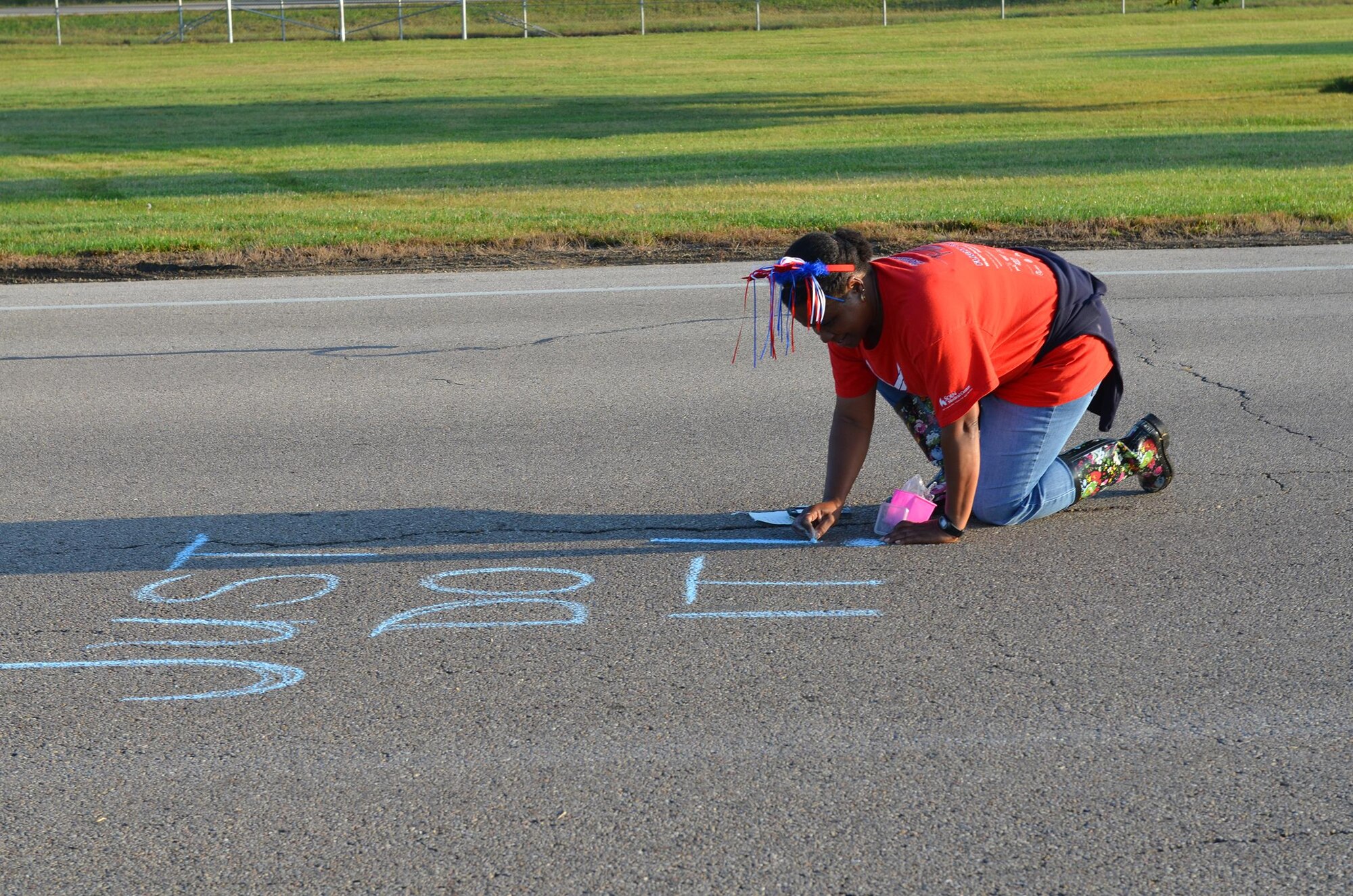 Master Sgt. Cynthia Holland, 445th Operations Group NCO in charge of administration, writes an encouraging message near the 445th Airlift Wing hydration station to participants in the 2017 Air Force Marathon Sept. 16. (U.S. Air Force photo/Lt. Col. Cynthia Harris)