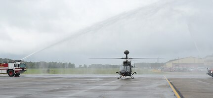 An OH-58D “Kiowa Warrior” passes through water from fire trucks after its final flight at Joint Base Langley-Eustis, Va., Sept. 18, 2017.