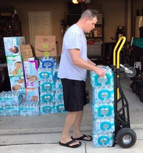 Capt. Gary E. Miller, of U.S. Army 5th Medical Recruiting Battalion, stacks cases of donated water before loading them into a trailer. He collected and delivered approximately 1,500 pounds of food, water and supplies Sept. 2 to aid in Hurricane Harvey relief efforts.