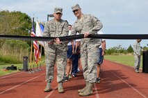 (From left) U.S. Air Force Col. Sean Tyler, 633rd Air Base Wing commander, and Tech. Sgt. Talbert, 36th Intelligence Squadron geospatial production analyst, cut the ceremonial ribbon to officially begin the 24-hour vigil run in honor of prisoners of war and those missing in action at Joint Base Langley-Eustis, Va., Sept. 14, 2017.