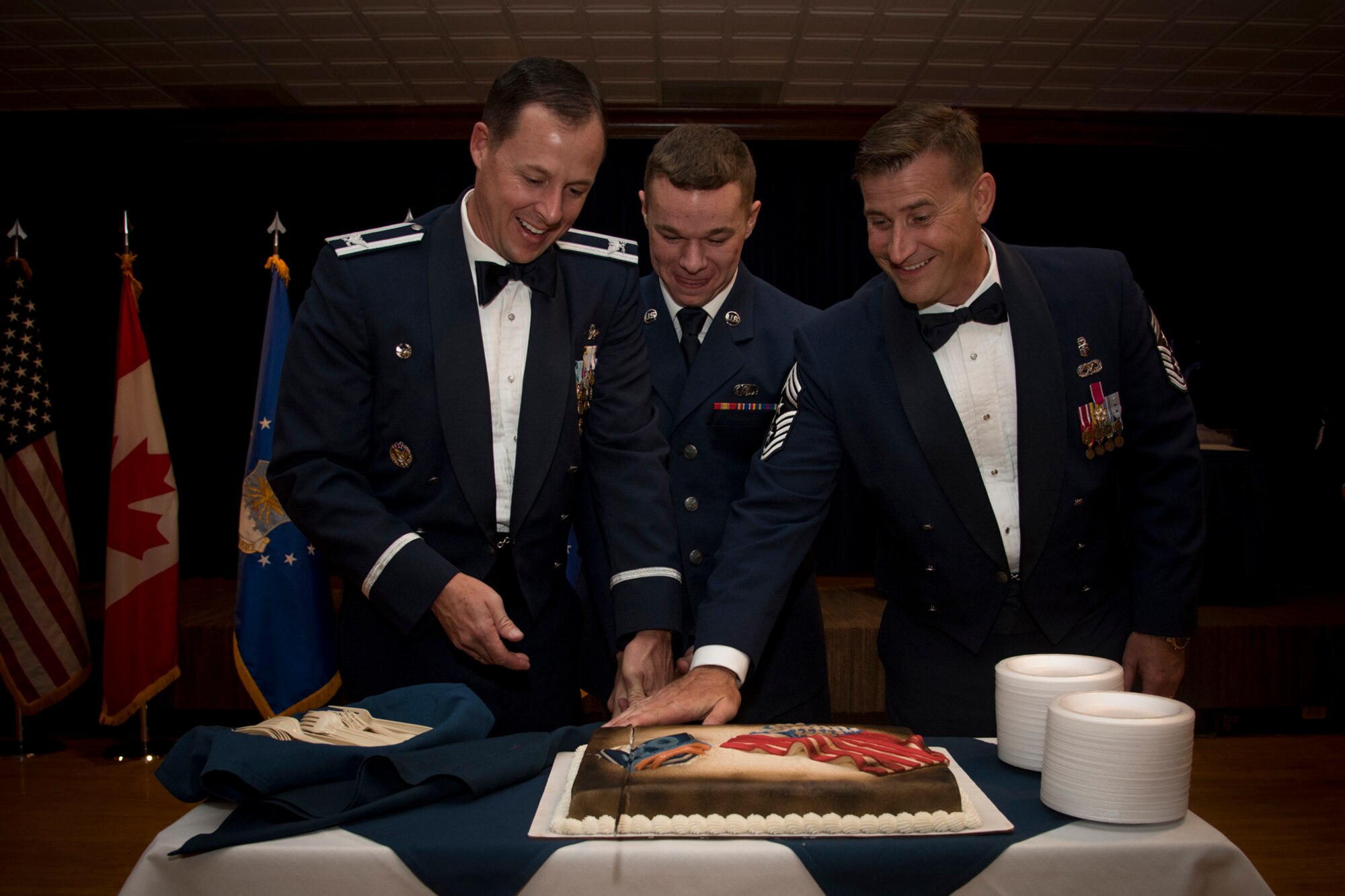 Col. Todd Moore (left), 21st Space Wing commander, Chief Master Sgt. Mark Bronson (right), 21st SW command chief, and Airman Donavan Yurick (middle), 21st Operations Support Squadron airfield management operations controller, slice the birthday cake at the Air Force Ball on Peterson Air Force Base, Colorado, Sept. 15, 2017. Traditionally, the lowest ranking Airman and the highest ranking Airmen of the wing slice the birthday cake on the Air Force’s birthday. (U.S. Air Force photo by Senior Airman Dennis Hoffman)