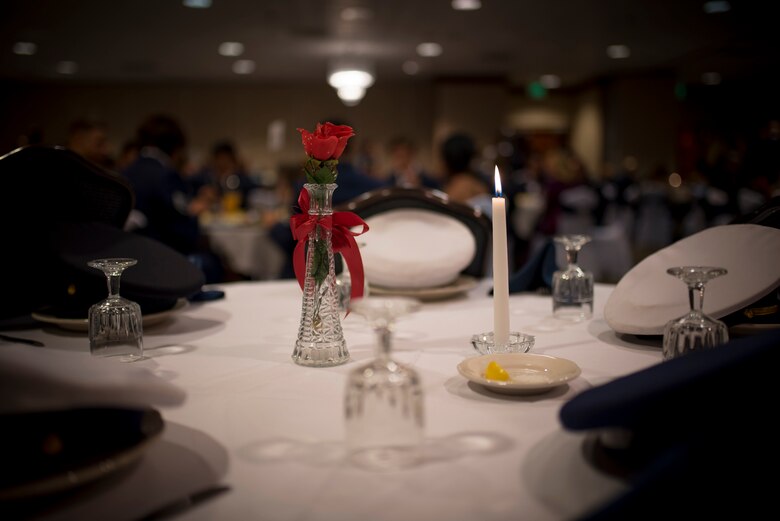 A table set for prisoners of war and the missing in action was placed near the front stage of the Air Force Ball at Peterson Air Force Base, Colorado, Sept. 15, 2017. The POW/MIA table has been a traditional sight at major Armed Forces events since the end of Vietnam War. (U.S. Air Force photo by Senior Airman Dennis Hoffman)