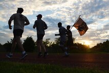 Runners hold the POW/MIA flag during the 24-hour vigil run in recognition of prisoners of war and those missing in action at Joint Base Langley-Eustis, Va., Sept. 14, 2017.