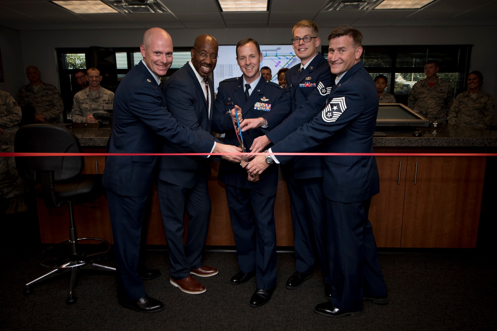 Col. Todd Moore (center), 21st Space Wing commander, alongside 21st SW leadership cut the ceremonial ribbon officially launching the new Peterson Air Force Base Flight Planning Room at Peterson Air Force Base, Colorado, Sept. 15, 2017. The new room will allow visiting pilots an area to prepare all flight publications in a digital capacity alieving the cost of paper-based flight publications. (U.S. Air Force photo by Senior Airman Dennis Hoffman)