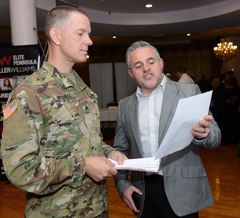 U.S. Army Sgt. David Mitchell, U.S. Army Training and Doctrine Command Band musician, speaks with Toby Siler, a realtor, during a job fair at Joint Base Langley-Eustis, Va., Sept. 14, 2017.