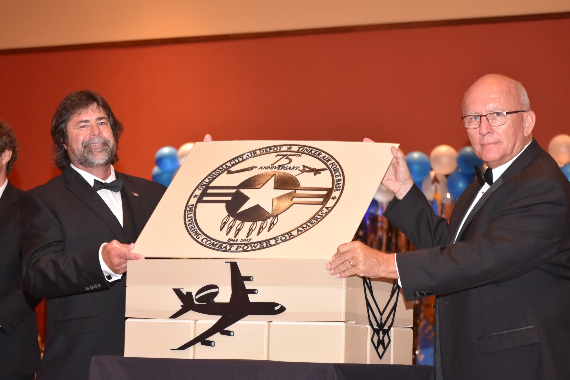 Phil Tinker, grandson of Maj. Gen. Clarence Tinker, and Jim Diehl, president of the Tinker Heritage Foundation, place the lid on top of the 75th anniversary time capsule during the 2017 Air Force Ball, held on Sept. 16 at the Embassy Suites Hotel in Norman, Oklahoma.
