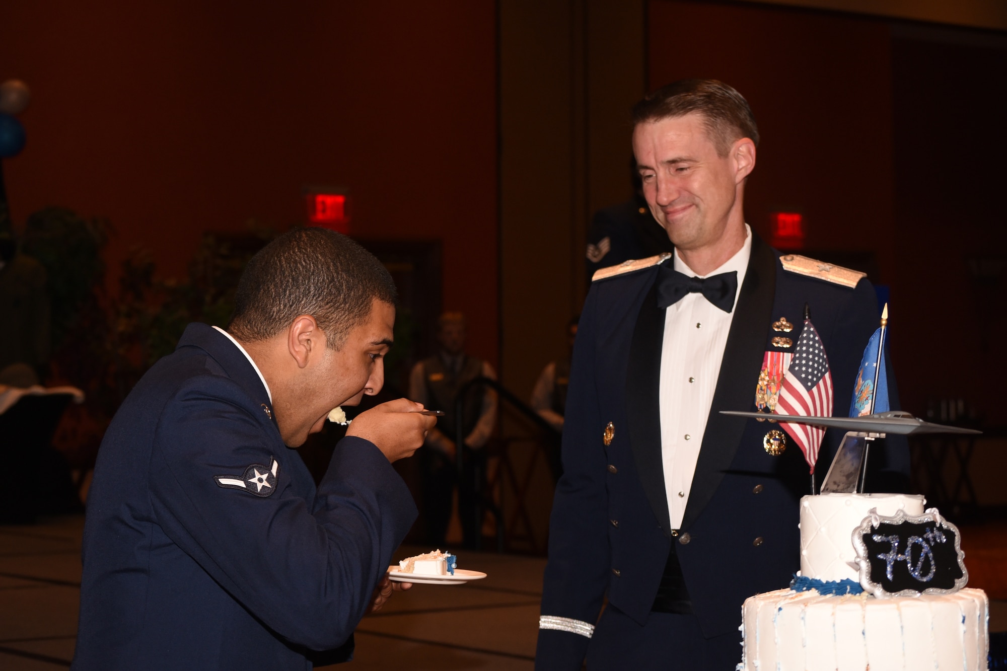 At the Air Force Ball on Sept. 16, 2017, Oklahoma City Air Logistics Center Commander Brig. Gen. Tom Miller, looks on as Airman William Parker from the 72nd Air Base Wing Comptroller Squadron, takes the first bite of the ceremonial cake to honor the U.S. Air Force's 70th birthday.